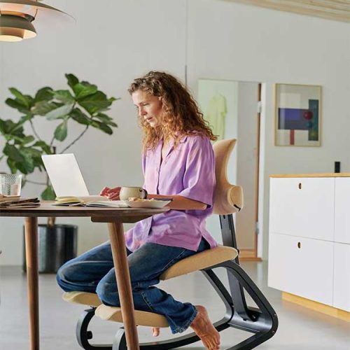woman sitting on thatsit chair at desk