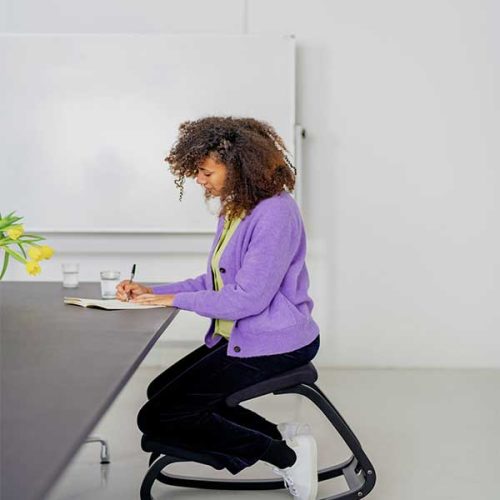 woman sitting on black upholstered variable balans with black frame